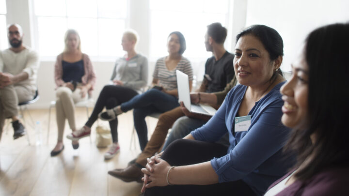 Individuals sitting in a circle in a group discussion setting